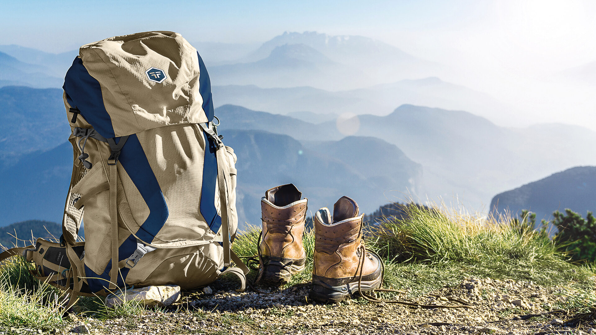 Hiking equipment. Backpack and boots on top of mountain Corno di Tres, Tresner Horn, Trentino, South Tyrol, Val di Non, Val d’Adige, Alps, Italy.